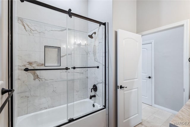 full bath featuring baseboards and bath / shower combo with glass door