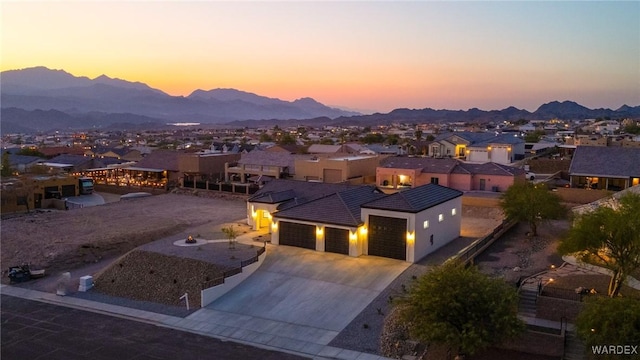 aerial view at dusk featuring a residential view and a mountain view