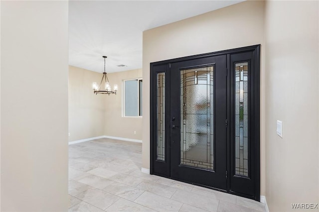 entrance foyer with baseboards and a notable chandelier