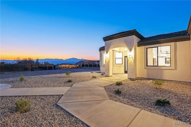 view of exterior entry featuring a mountain view and stucco siding