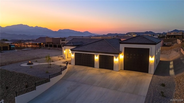 single story home with a garage, a residential view, a mountain view, and driveway