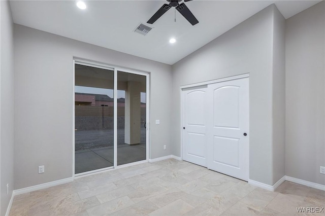 unfurnished bedroom featuring a closet, visible vents, vaulted ceiling, and baseboards