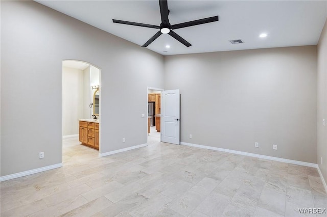 unfurnished bedroom with arched walkways, recessed lighting, visible vents, and baseboards