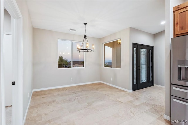 unfurnished dining area featuring baseboards, visible vents, and a notable chandelier