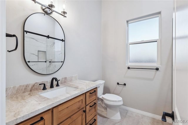 bathroom featuring toilet, baseboards, an enclosed shower, and vanity