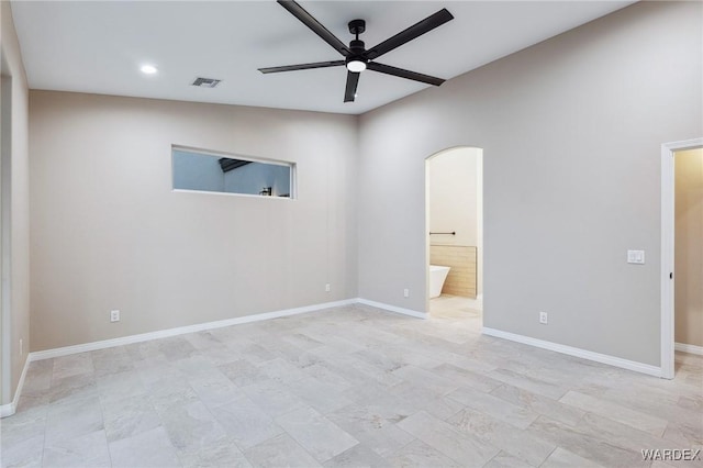 unfurnished bedroom featuring arched walkways, visible vents, connected bathroom, and baseboards