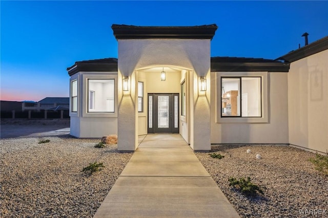 entrance to property featuring stucco siding