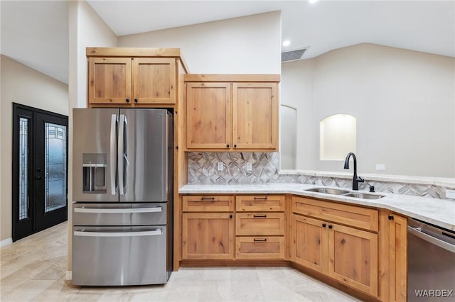 kitchen featuring stainless steel appliances, a sink, visible vents, decorative backsplash, and light stone countertops