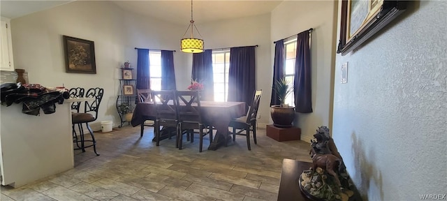 dining room featuring vaulted ceiling, wood finished floors, and baseboards