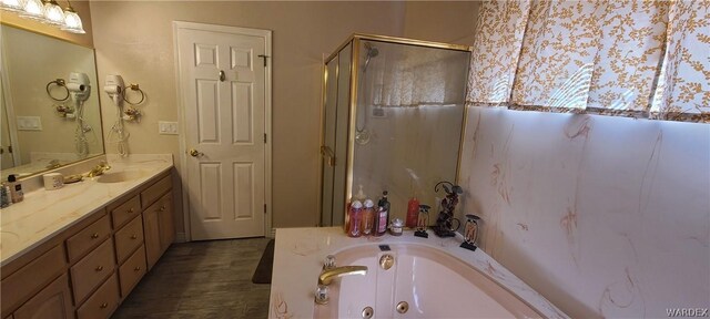 full bathroom featuring a whirlpool tub, a shower stall, and vanity