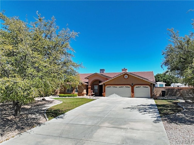 view of front of property with concrete driveway, a chimney, an attached garage, fence, and stucco siding