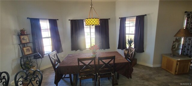 dining area featuring dark wood-style flooring, plenty of natural light, and baseboards