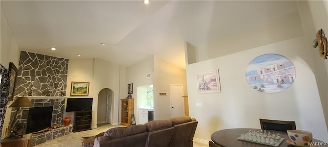 living room with arched walkways and a fireplace