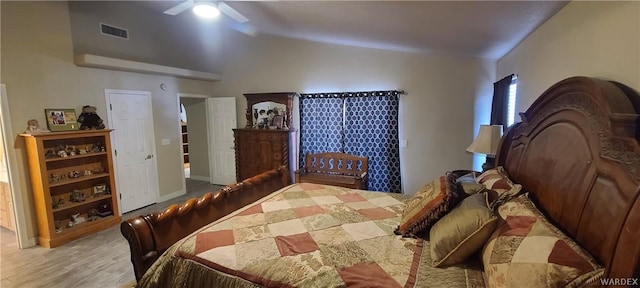 bedroom featuring lofted ceiling, visible vents, ceiling fan, and wood finished floors