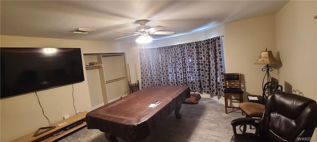 rec room with visible vents, ceiling fan, and wood finished floors