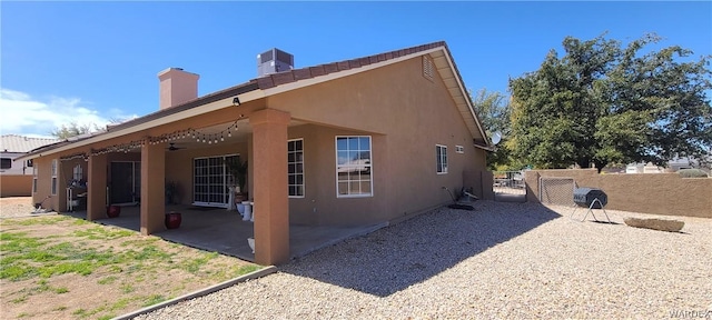 view of home's exterior with a patio, stucco siding, ceiling fan, fence, and cooling unit