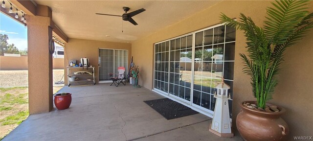 view of patio with ceiling fan and fence