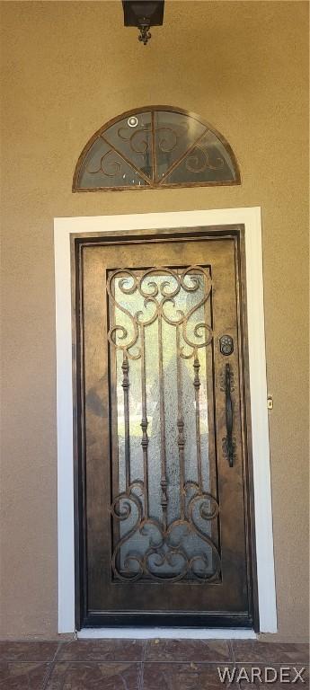 doorway to property featuring stucco siding