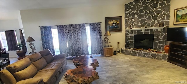 living room featuring a stone fireplace