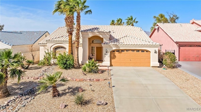 view of front of house featuring a tiled roof, an attached garage, driveway, and stucco siding