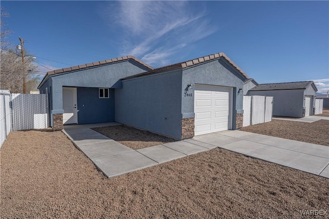 single story home featuring an attached garage, fence, stone siding, driveway, and stucco siding