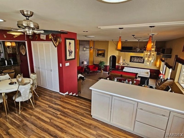 kitchen featuring light countertops, wood finished floors, decorative light fixtures, and white cabinets