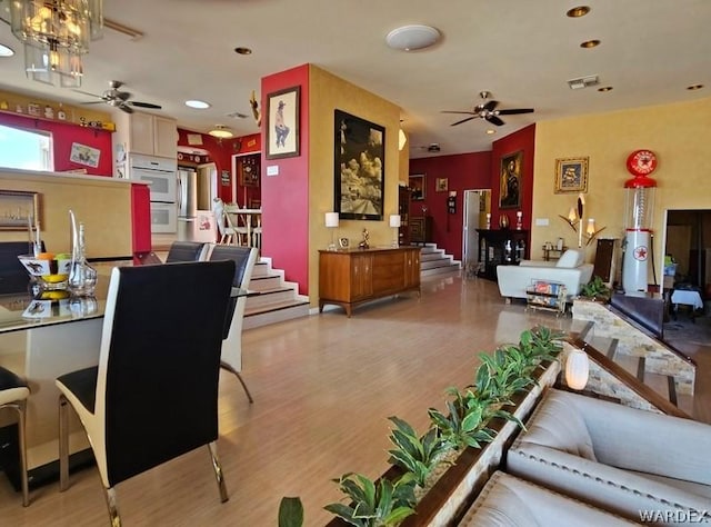 living room featuring recessed lighting, visible vents, a ceiling fan, stairs, and light wood-style floors