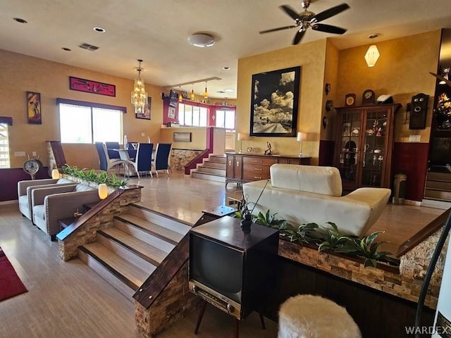 living room with visible vents, stairway, wood finished floors, and a wealth of natural light