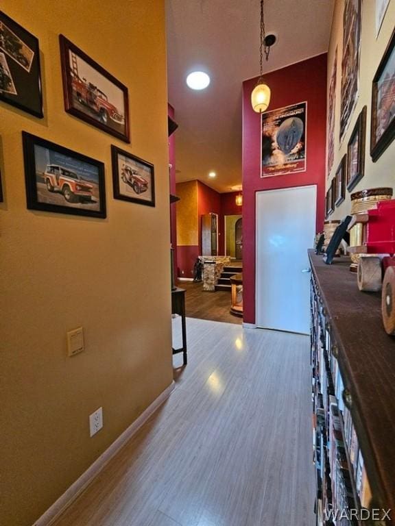 corridor with dark wood-style floors, recessed lighting, and baseboards