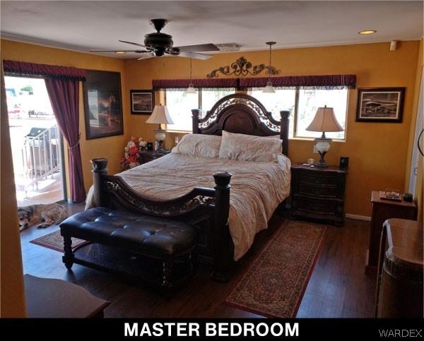 bedroom featuring a ceiling fan, access to outside, multiple windows, and dark wood finished floors