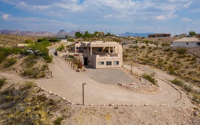 back of house with a mountain view and stucco siding