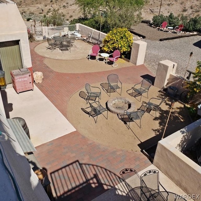 view of patio / terrace with exterior fireplace and fence