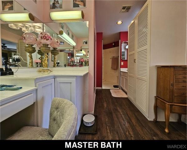 bathroom with recessed lighting, wood finished floors, vanity, visible vents, and a closet