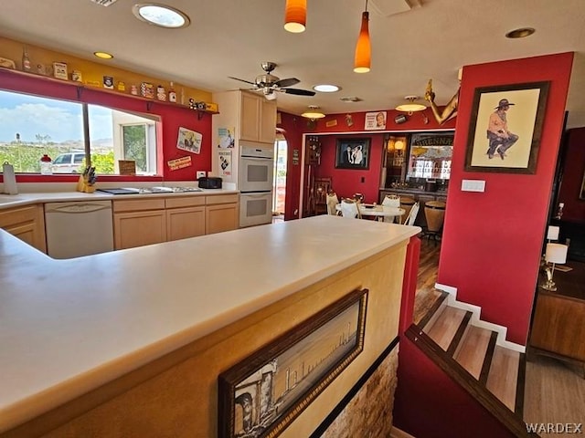 kitchen with dark wood-type flooring, white appliances, light countertops, and light brown cabinetry