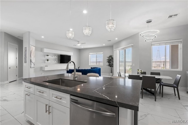 kitchen with a center island with sink, white cabinets, dishwasher, hanging light fixtures, and a sink