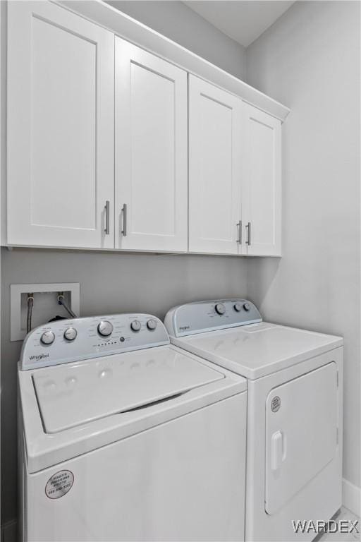 laundry room featuring cabinet space, baseboards, and separate washer and dryer