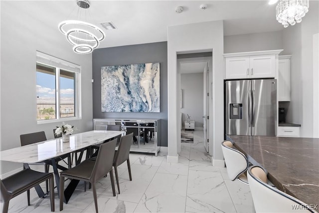 dining room featuring marble finish floor, visible vents, a chandelier, and baseboards