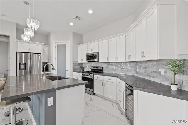 kitchen with stainless steel appliances, white cabinets, and a sink