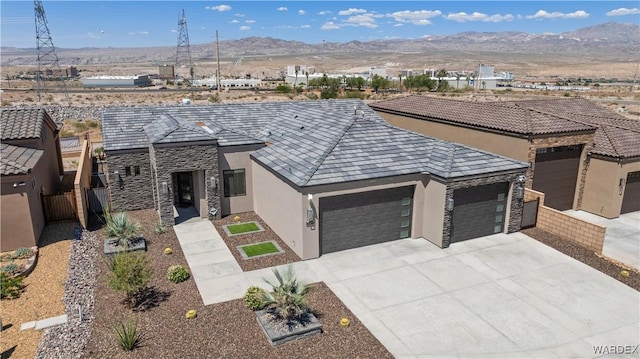 view of front of home with driveway, a garage, a mountain view, and stucco siding