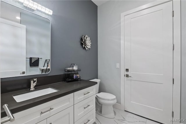 half bath with marble finish floor, vanity, and toilet