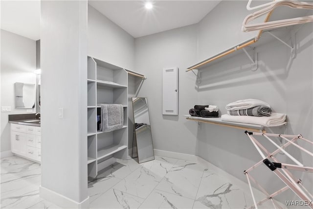 spacious closet featuring marble finish floor and a sink