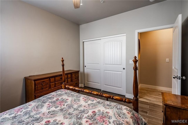 bedroom with a ceiling fan, a closet, baseboards, and wood finished floors