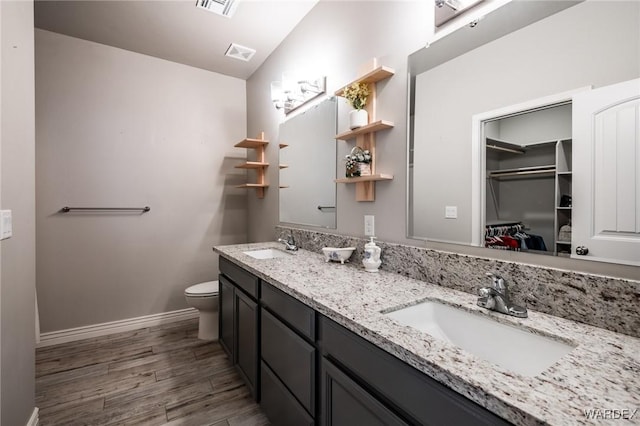 full bath with visible vents, a sink, a spacious closet, and wood finished floors