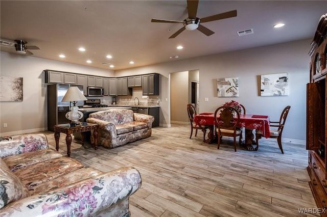 living area featuring light wood-type flooring, visible vents, and recessed lighting