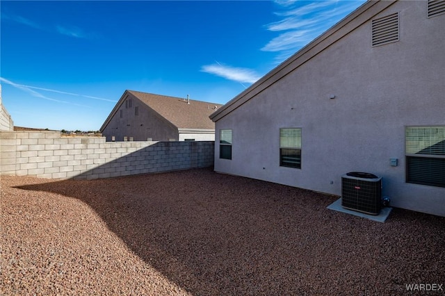 view of yard featuring fence and central AC unit