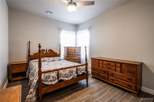 bedroom featuring a ceiling fan, wood tiled floor, visible vents, and baseboards