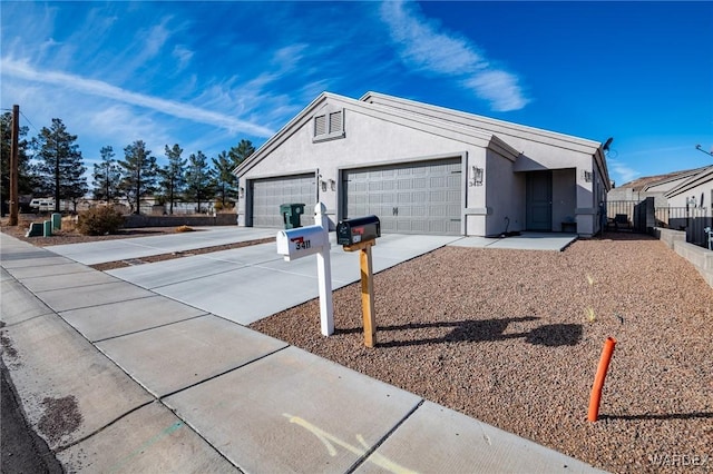 garage featuring concrete driveway and fence