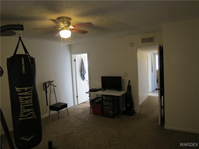 interior space with ceiling fan, visible vents, dark carpet, and a textured ceiling