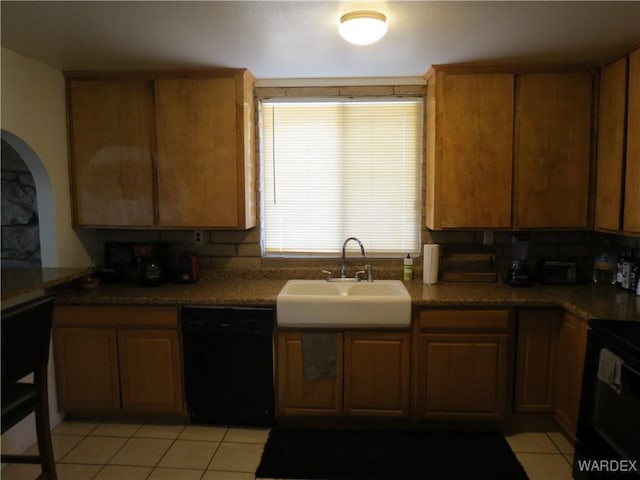 kitchen featuring black appliances, brown cabinets, a sink, and light tile patterned flooring