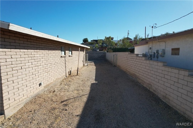 view of property exterior with fence and brick siding